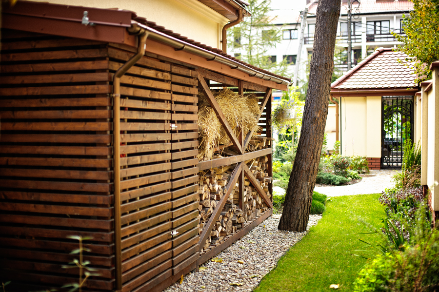 Estetyczna drewutnia przy ścianie domu